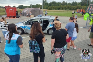 Zdjęcia przedstawiają policjantów oraz radiowozy uczestniczące w pikniku dla dzieci i młodzieży
