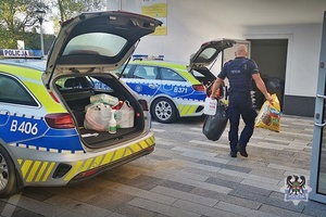 Na zdjęciu policjant przygotowujący dary dla osób potrzebujących.