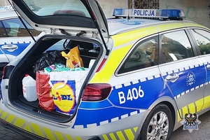 Na zdjęciu policjant przygotowujący dary dla osób potrzebujących.