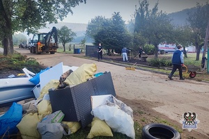 Na zdjęciu policjanci pracują przy porządkowaniu terenów zielonych