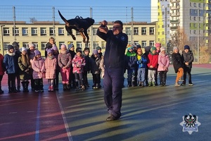 Na zdjęciu policjant podczas pokazu psa służbowego z udziałem dzieci.