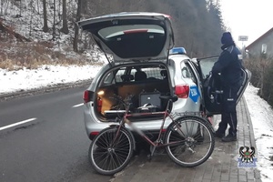 Na zdjęciu rower, policjant oraz radiowóz.