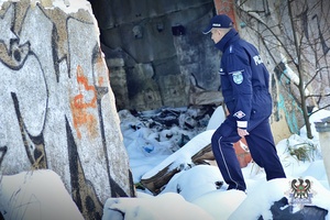 Na zdjęciu policjant podczas patrolu opuszczonych terenów gospodarczych.