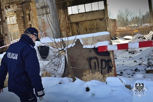 Na zdjęciu policjant podczas patrolu opuszczonych terenów gospodarczych.