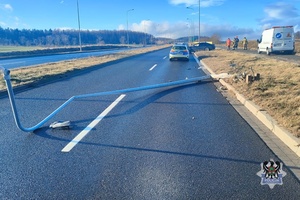 Na zdjęciu uszkodzony w wyniku kolizji drogowej samochód osobowy oraz leżąca na ulicy latarnia.