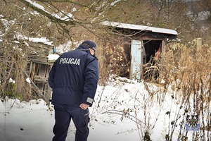 Na zdjęciu policjant podczas patrolu terenów opuszczonych działek.