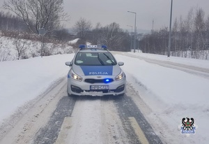 Na zdjęciu radiowóz na zaśnieżonej drodze.