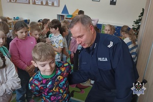 Na zdjęciu policjant demonstruje w jaki sposób zakłada się kajdanki.