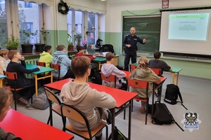 Na zdjęciu policjant podczas prowadzenia warsztatów dla uczniów.