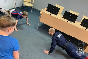 Na zdjęciu policjant oraz dzieci, które odwiedziły Komendę Miejską Policji w Wałbrzychu.