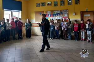 Na zdjęciu policjant podczas pogadanki z uczniami.