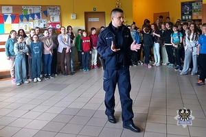 Na zdjęciu policjant podczas pogadanki z uczniami.