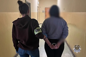 Na zdjęciu policjantka prowadzi kobietę zatrzymaną za posiadanie narkotyków.