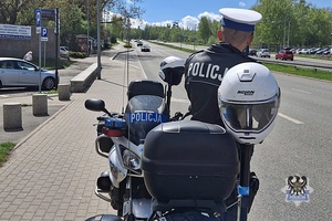 Na zdjęciu policjant przy motocyklu.