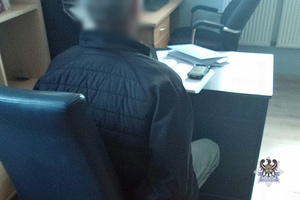 Na zdjęciu zatrzymany mężczyzna w kajdankach.