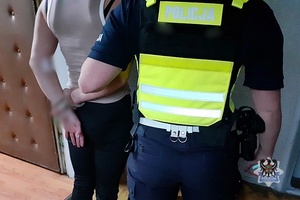 Na zdjęciu policjantka pilnuje zatrzymanej kobiety.