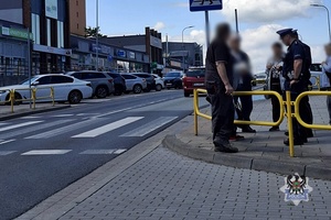 Na zdjęciu policjanci rozmawiają ze świadkami.