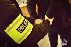 Na zdjęciu policjant zakłada kajdanki zatrzymanemu mężczyźnie.