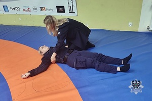 Na zdjęciu policjanci podczas zajęć na hali sportowej.