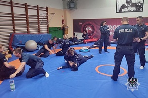 Na zdjęciu policjanci podczas zajęć na hali sportowej.