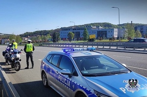 Na zdjęciu policjanci przy radiowozie oraz motocyklach.