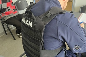 Na zdjęciu policjant sporządza dokumentację służbową.