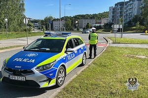 Na zdjęciu policyjny radiowóz oraz policjant.