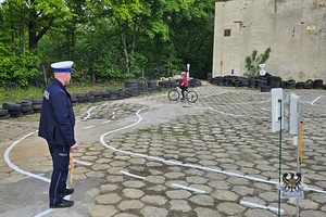 Na zdjęciu policjant podczas prowadzenia egzaminu na kartę rowerową.