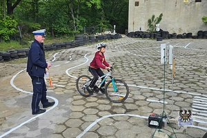 Na zdjęciu policjant podczas prowadzenia egzaminu na kartę rowerową.