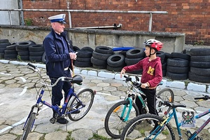 Na zdjęciu policjant podczas prowadzenia egzaminu na kartę rowerową.