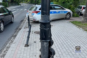 Na zdjęciu uszkodzona latarnia i radiowóz.