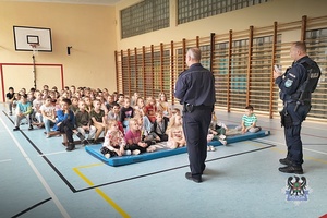 Na zdjęciu policjanci podczas przykładowej pogadanki z dziećmi.