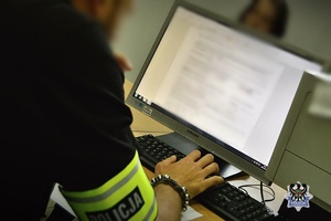 Na zdjęciu policjant pracuje przy komputerze.