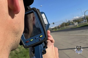 Na zdjęciu policjant z ręcznym miernikiem prędkości.