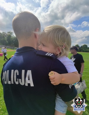 Policjant trzyma córkę na rękach