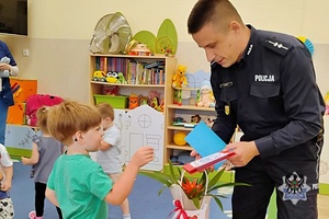 Na zdjęciu policjant w trakcie rozmowy z przedszkolakami.