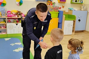 Na zdjęciu policjant w trakcie rozmowy z przedszkolakami.
