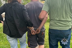 Na zdjęciu nieumundurowani policjanci prowadzą zatrzymanego mężczyznę.