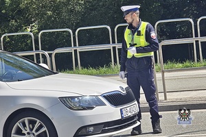 Na zdjęciu policjant w trakcie kierowania ruchem na drodze.