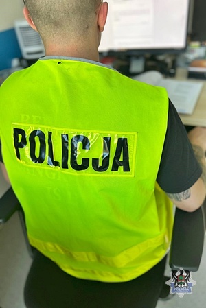 Na zdjęciu policjant siedzący przy komputerze.