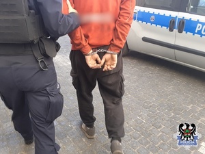 zatrzymany prowadzony przez policjantkę do radiowozu