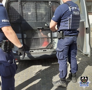 policjanci zamykają  radiowóz z kartą