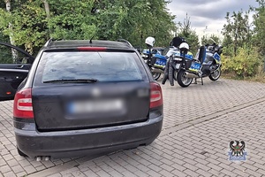 Na zdjęciu policjanci prowadzą zatrzymanego meżczyznę.