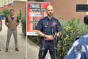 Na zdjęciu policjant podczas rozmowy z dziennikarzami.