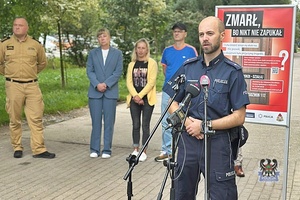 Na zdjęciu policjant podczas rozmowy z dziennikarzami.