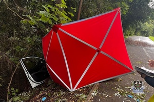 Na zdjęciu parawan oraz uszkodzony w wyniku wypadku samochód.