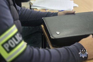 Na zdjęciu policjant przygotowuje dokumentację służbową.