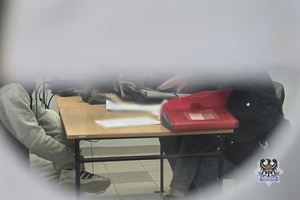 Na zdjęciu policjanci wykonują czynności służbowe z zatrzymanym.