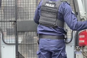 Na zdjeciu policjant zakłada kajdanki zatrzymanej osobie.