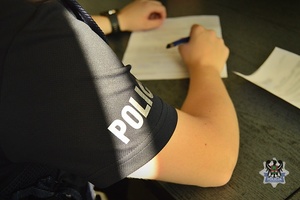 Na zdjęciu policjant sporządza dokumentację.
